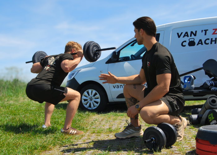 Personal trainer Justin begeleidt een squatoefening
